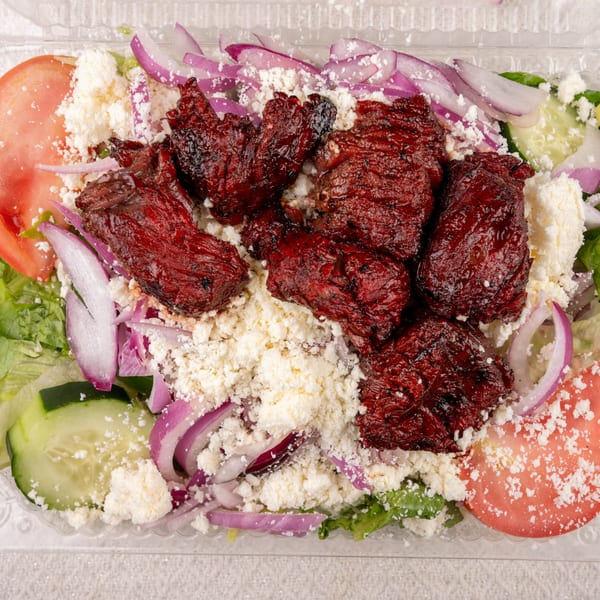 Pete's-A-Place salad with dark red meat, feta cheese, red onions, tomatoes, and cucumbers.