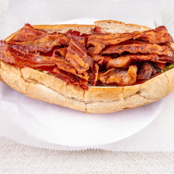 Pete's-A-Place's bacon sub sandwich, overflowing with crispy bacon strips on a white plate.