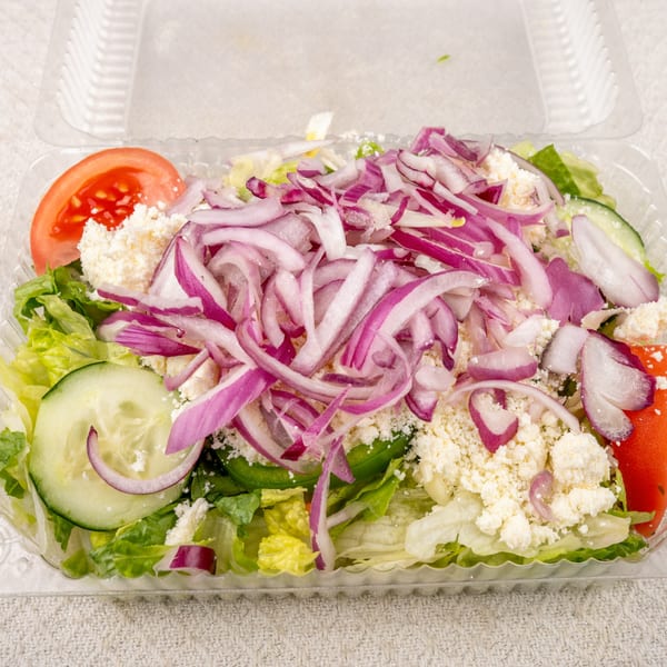 A fresh salad from Pete's-A-Place with lettuce, tomatoes, cucumbers, red onions, and crumbled feta cheese.